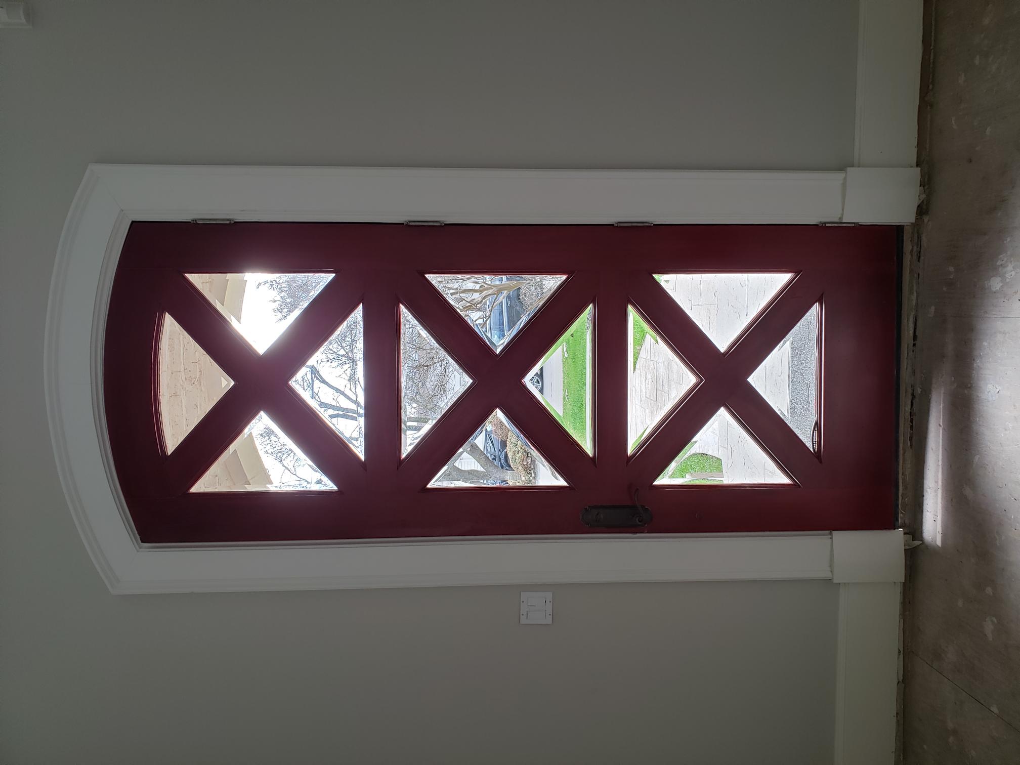 Residential entry door with decorative diamond pattern film
