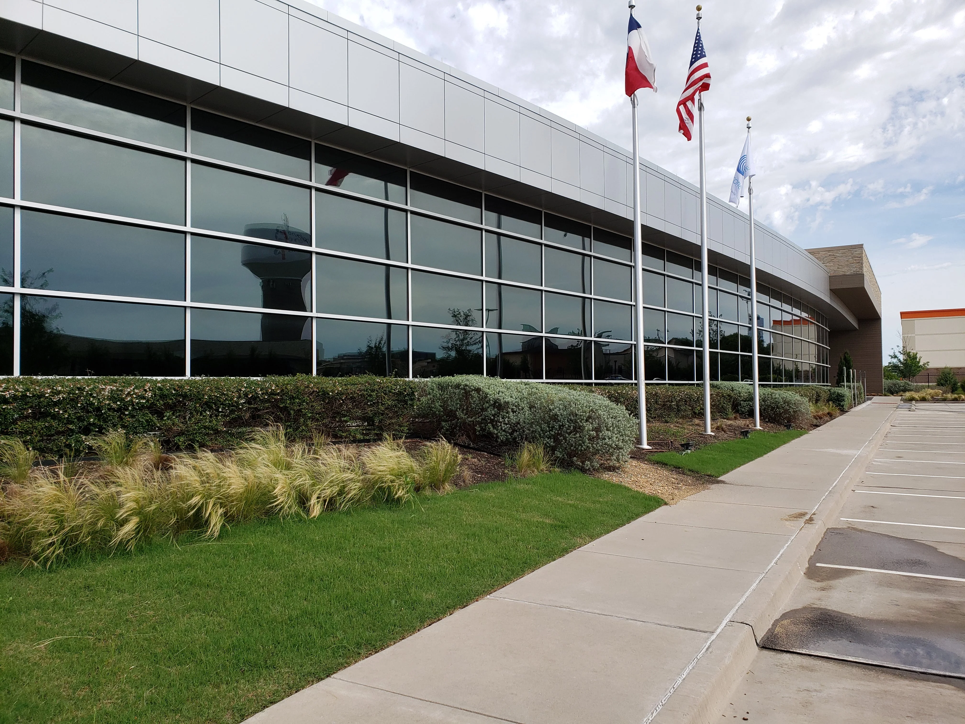 Corporate campus reflective glass curtain wall Texas flags DFW