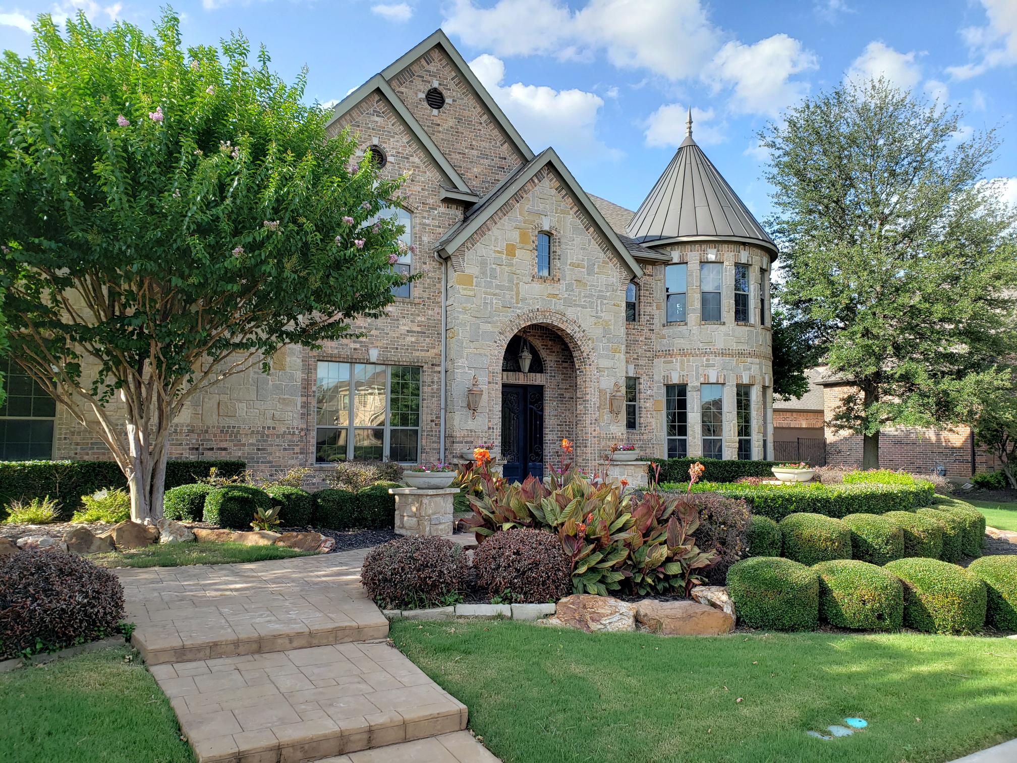 French chateau style brick and stone home with dark window film