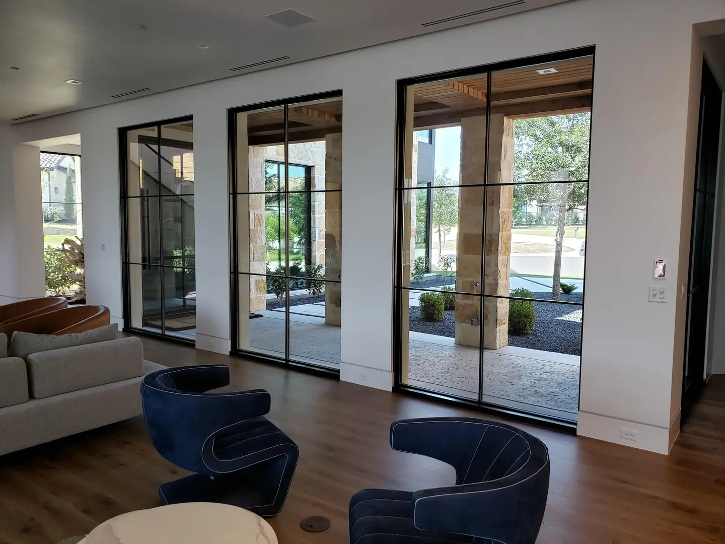 Luxury home three floor-to-ceiling steel framed windows courtyard view