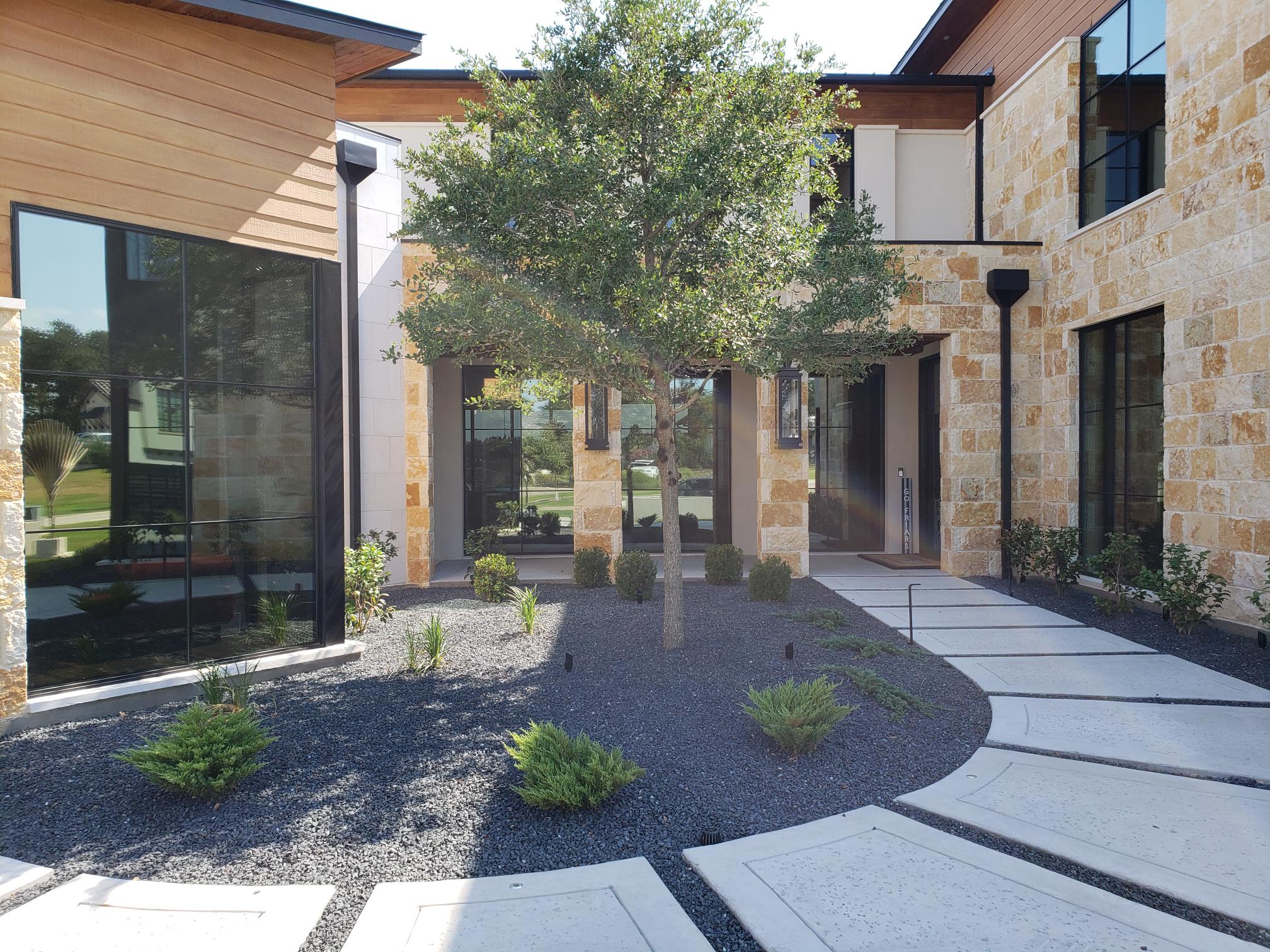 Home interior courtyard view through black steel-framed glass door